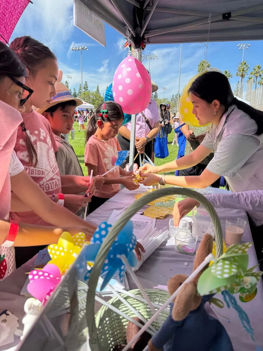 Children reach for balloons and crafts at the Polaris festival booth.