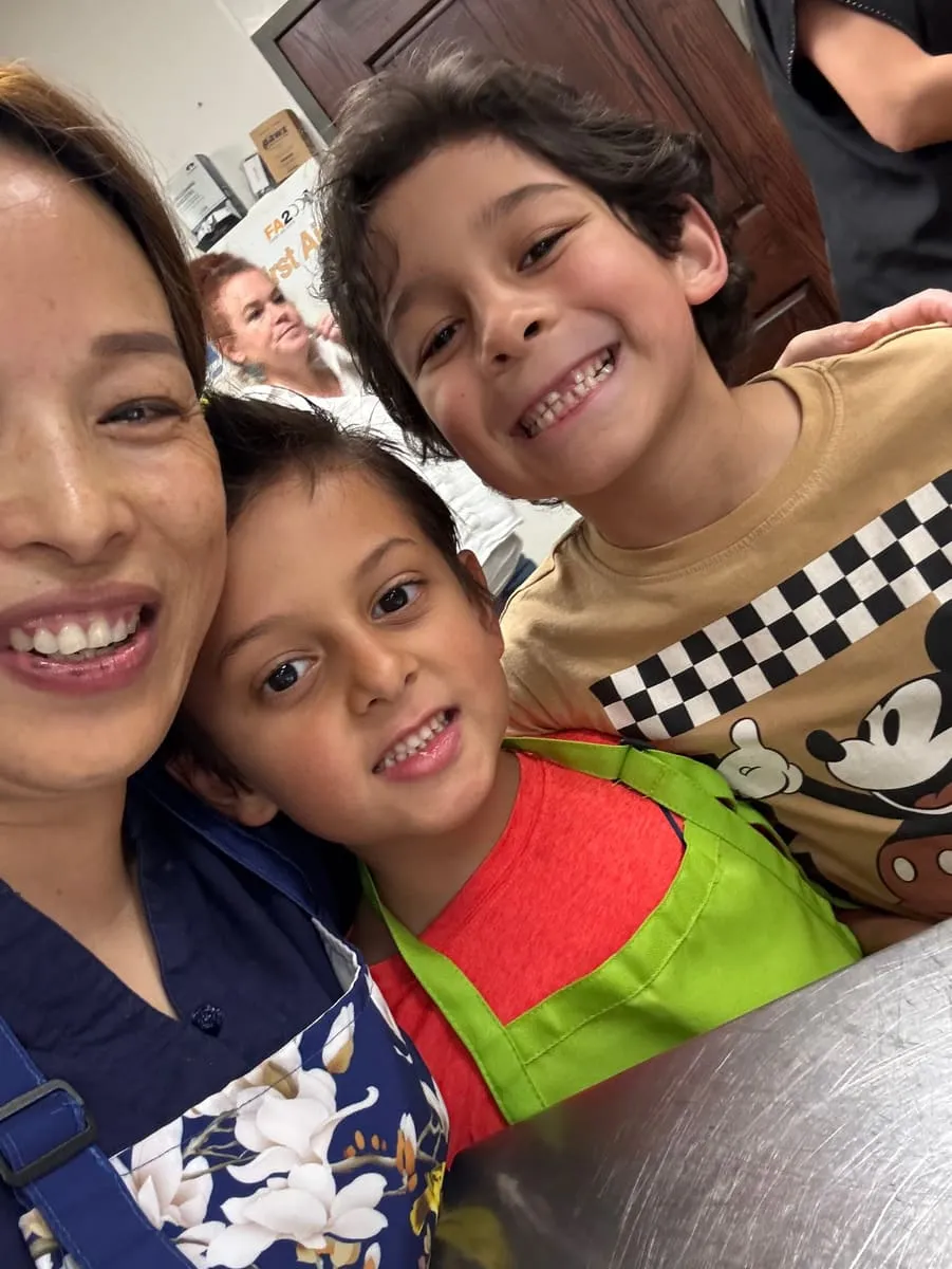 An instructor takes a selfie with two grinning boys.